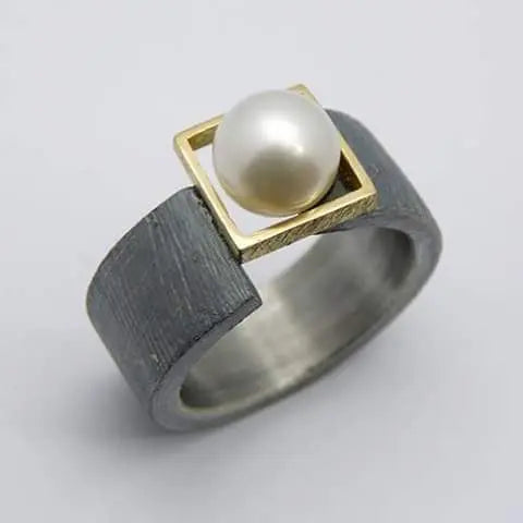 Dark Band Ring with Luminous Pearl and Golden Frame